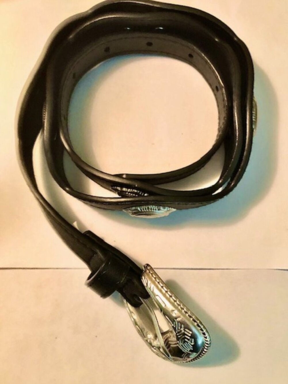 A black leather belt with sliver concha and an ornate silver buckle size 42 inch
